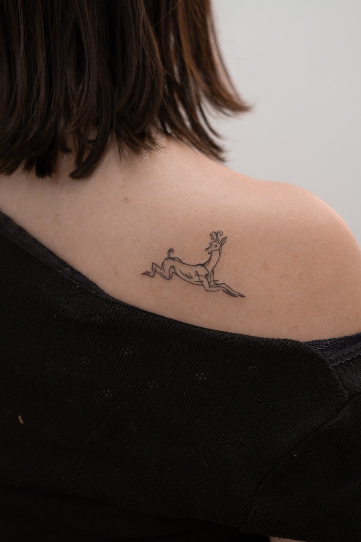 Fine-line deer tattoo on shoulder