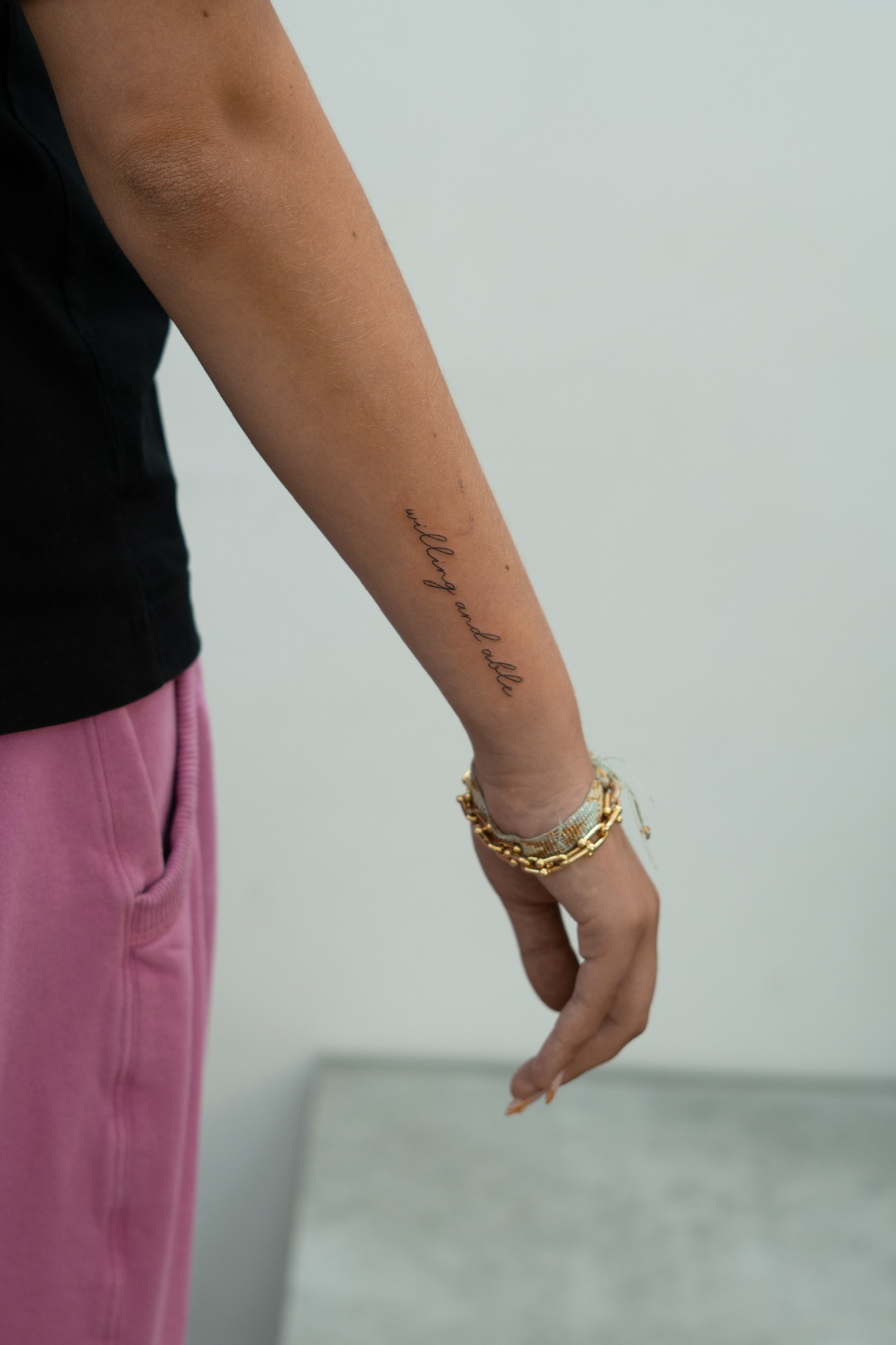 Fine-line writing tattoo on forearm